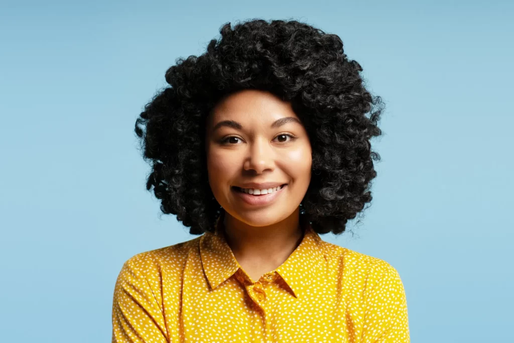 smiling woman with black curly hair in studio utc